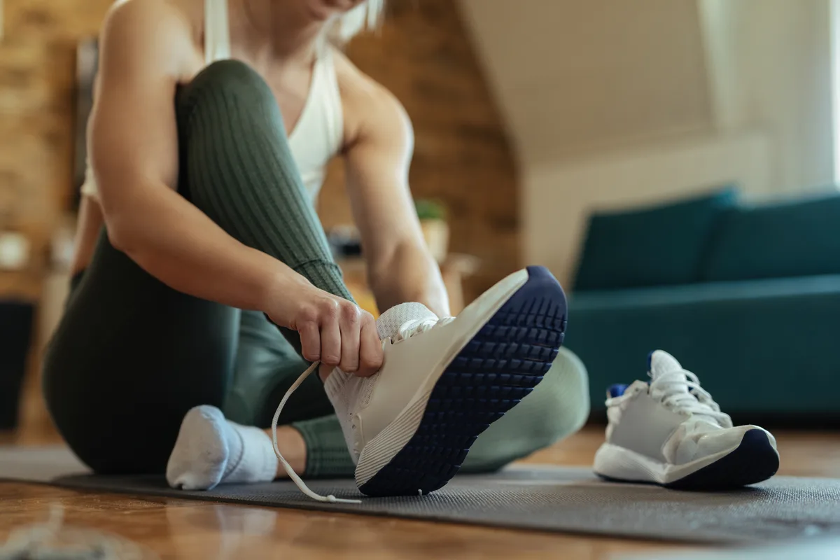An athlete puts on trainers for a training session